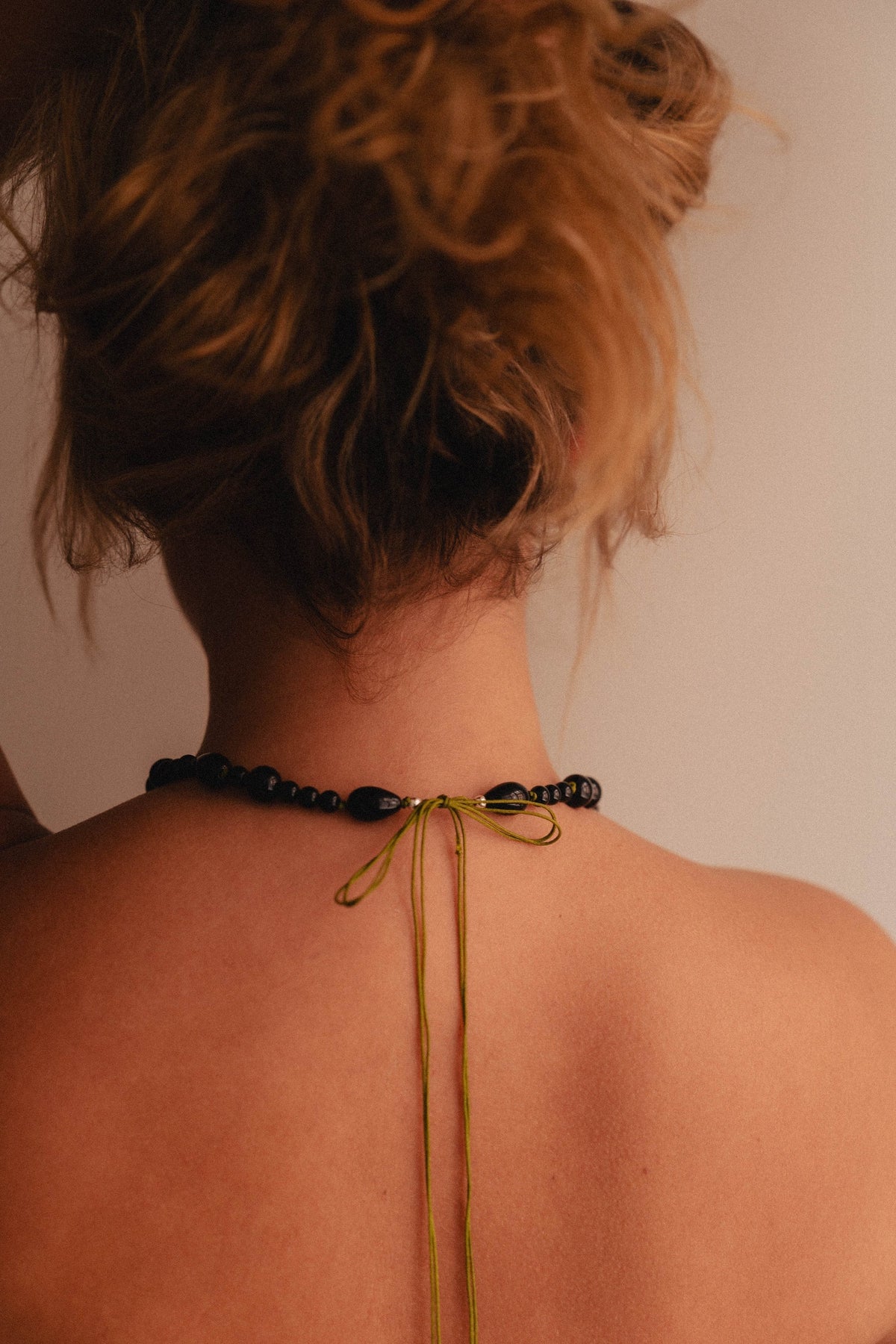 Knotted necklace closed with a silk ribbon at the back of the neck