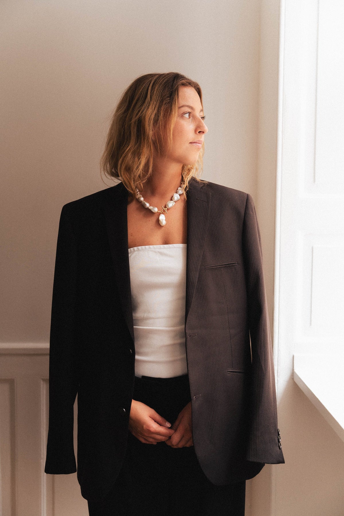 Freshwater pearl necklace worn with a black blazer